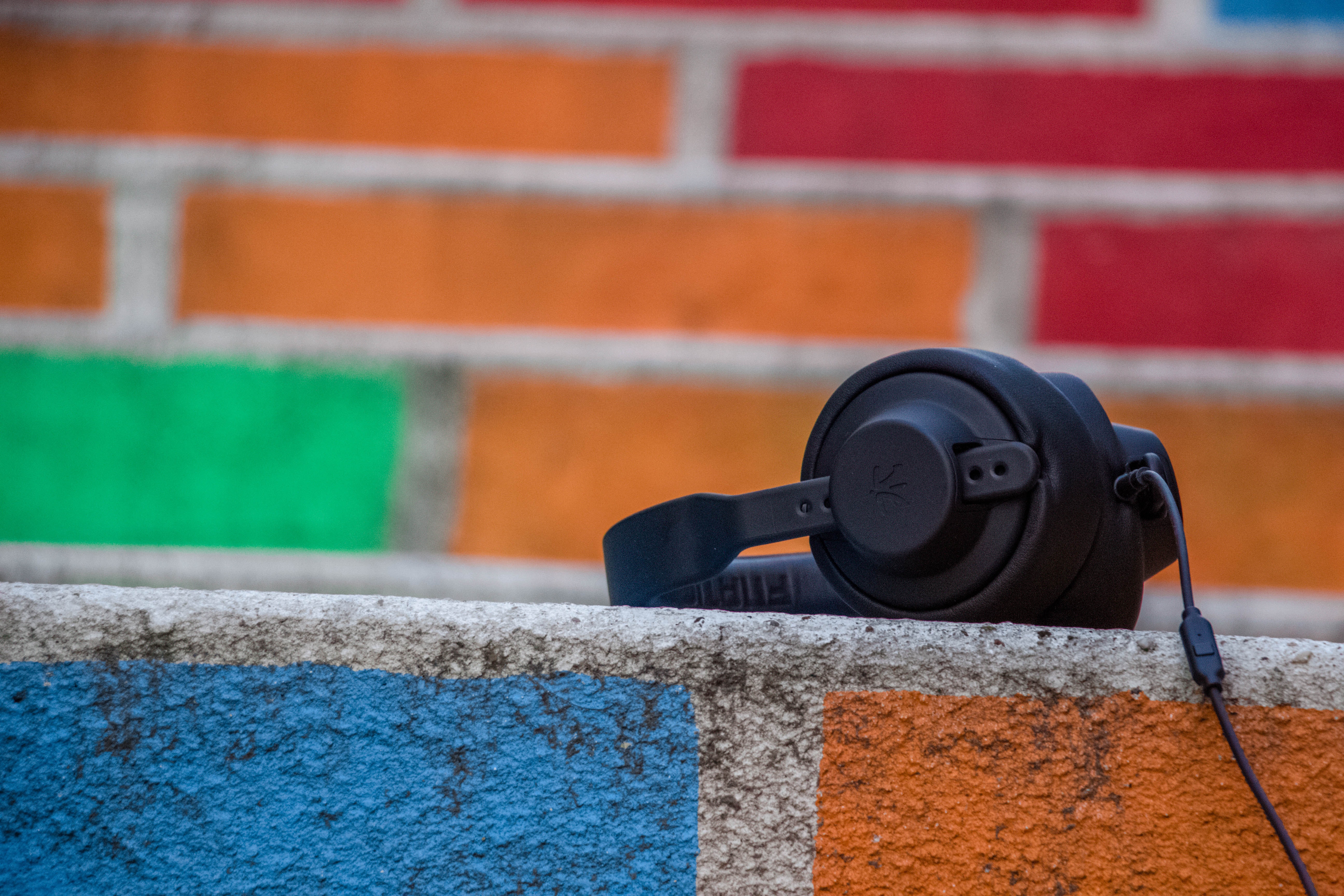 headphones sitting on a colorful brick wall